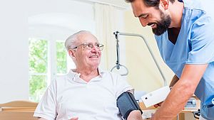 Nursing professional measures blood pressure of an elderly man